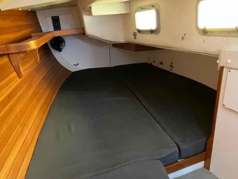 Slide: The Image of 1998 J Boats J 42 cabin interior with wooden paneling and black cushions. - 12