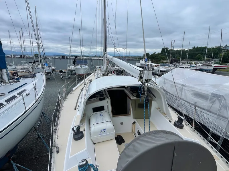 Slide: The Image of 1998 J Boats J 42 sailboat docked, surrounded by other vessels under cloudy skies. - 18