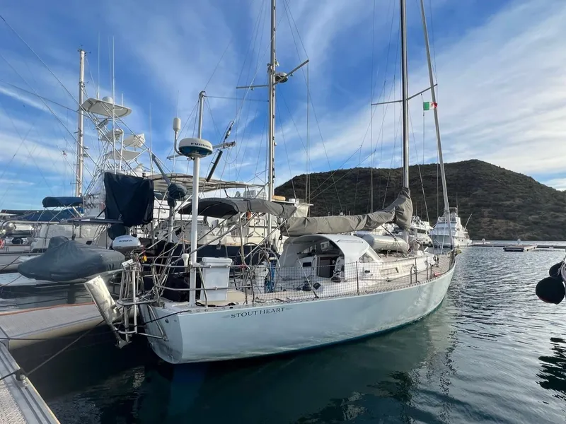 Slide: The Image of 1998 J Boats J 42 sailboat docked in a marina with scenic mountain backdrop. - 2
