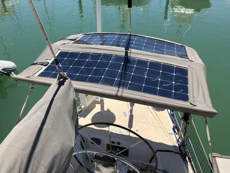 Slide: The Image of Sailboat J 42 (1998) with solar panels on deck, docked in calm waters. - 6