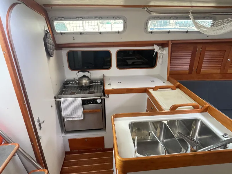 Slide: The Image of Interior of 1998 J Boats J 42 sailboat kitchen with stove, sink, and wooden cabinetry. - 8