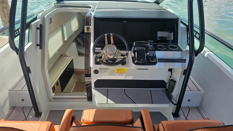 Slide: The Image of 2023 Saxdor 320 GTO cockpit with modern steering and controls, featuring orange seating. - 14