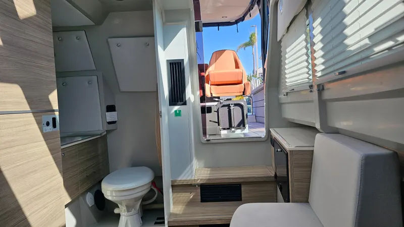 Slide: The Image of Interior of 2023 Saxdor 320 GTO boat, featuring a compact bathroom and seating area. - 21