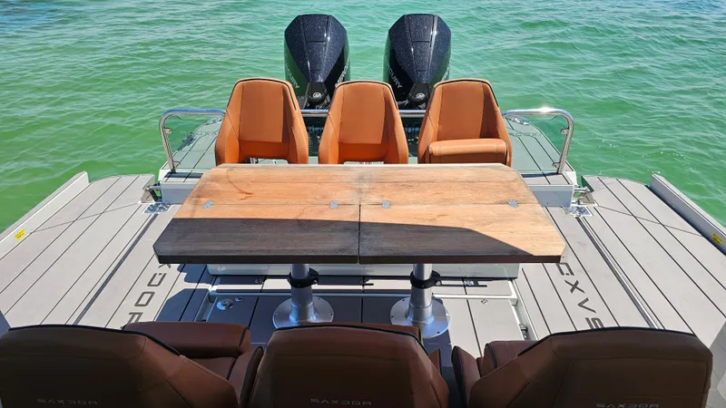 Slide: The Image of 2023 Saxdor 320 GTO boat interior with seating and table on calm water. - 26