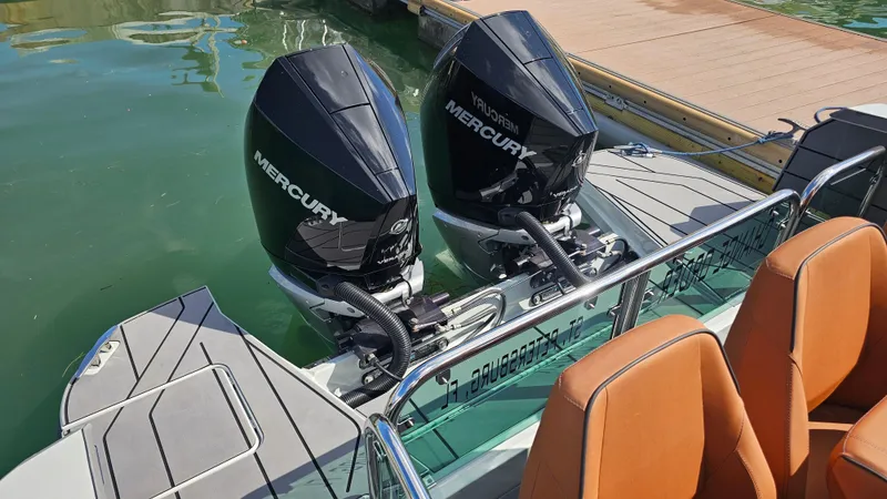 Slide: The Image of 2023 Saxdor 320 GTO with twin Mercury outboard engines docked on calm water. - 27