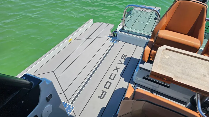 Slide: The Image of 2023 Saxdor 320 GTO boat deck with seating and table on green water. - 30