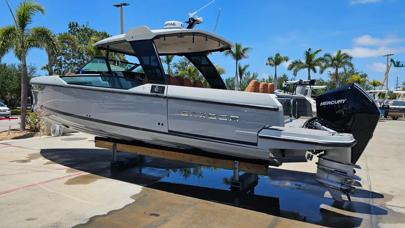 Slide: The Image of 2023 Saxdor 320 GTO boat on display, featuring sleek design and Mercury engine, surrounded by palm trees. - 36
