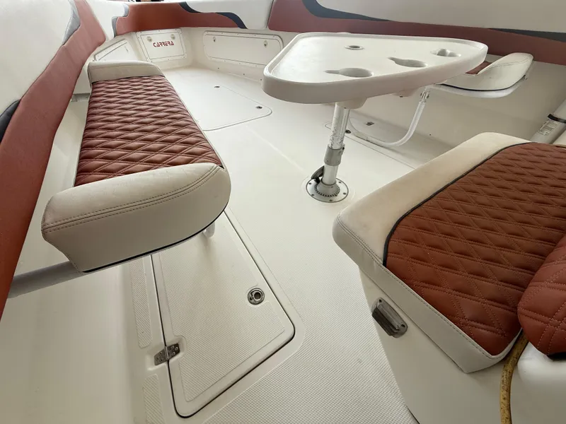 Slide: The Image of 2007 Carrera Boats 36 Center Console interior with red quilted seats and a white table. - 14