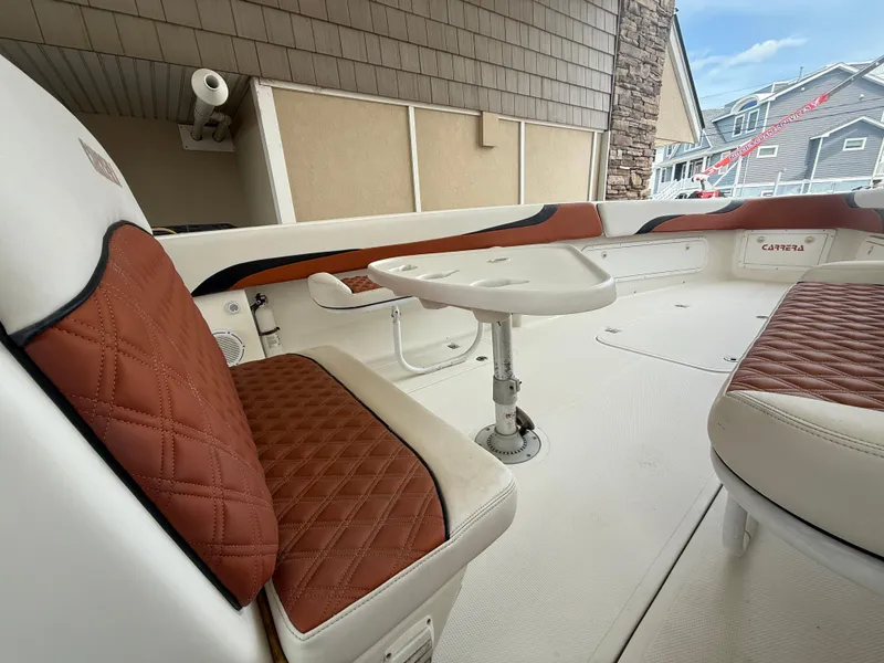 Slide: The Image of 2007 Carrera Boats 36 Center Console with brown quilted seating and a small table. - 16