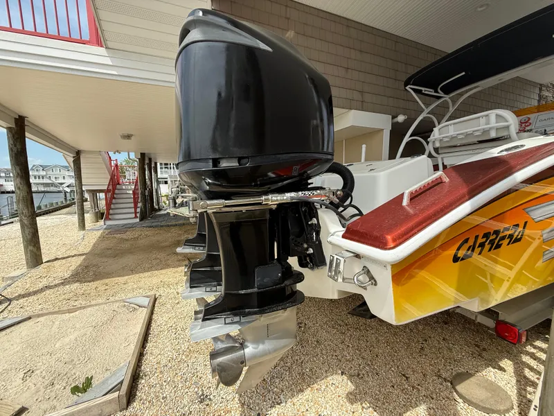 Slide: The Image of 2007 Carrera Boats 36 Center Console with powerful outboard engines, docked under a covered area. - 45