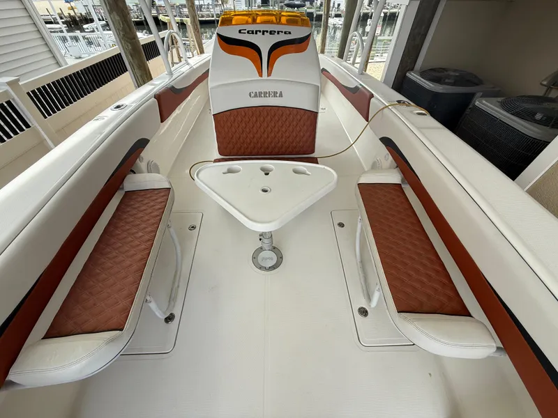 Slide: The Image of 2007 Carrera Boats 36 Center Console interior with brown and white seating and central table. - 48