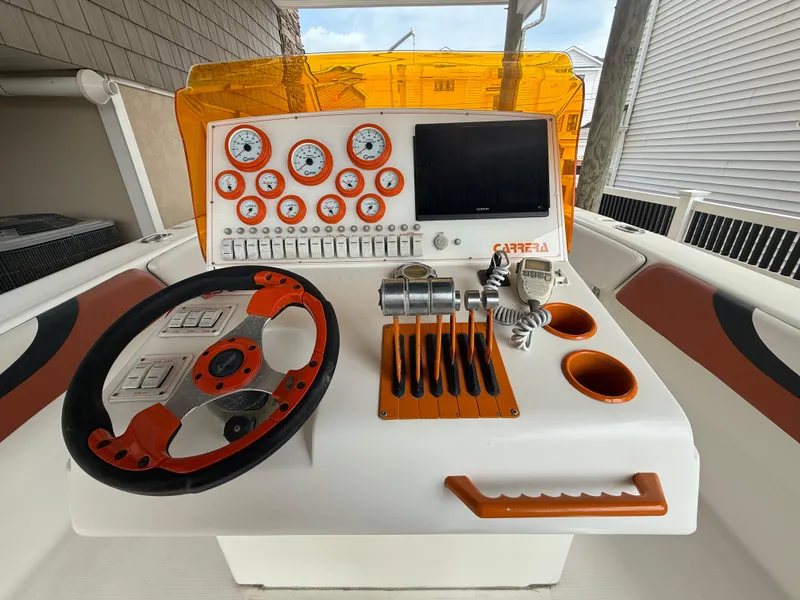 Slide: The Image of 2007 Carrera Boats 36 Center Console dashboard with orange accents and modern controls. - 5