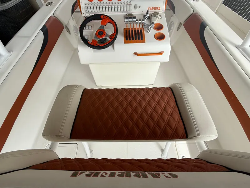 Slide: The Image of 2007 Carrera Boats 36 Center Console interior with brown seating and modern controls. - 8