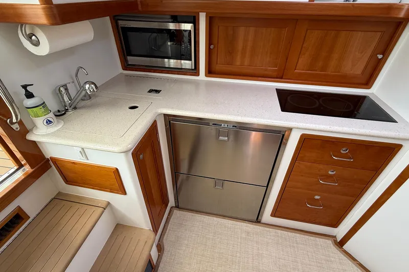 Slide: The Image of Compact galley kitchen in 2016 MJM 40z Downeast boat with modern appliances and wood cabinetry. - 31