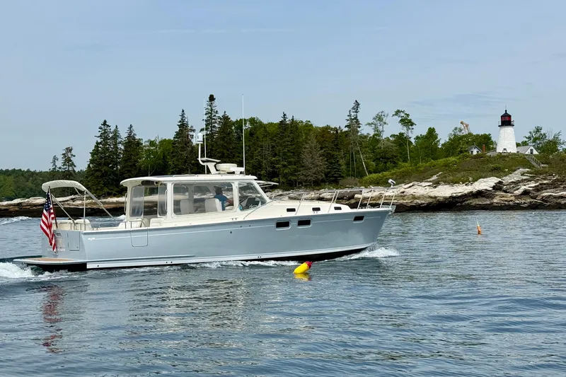 The Image of 2016 MJM 40z Downeast cruising near a lighthouse with American flag. - 0
