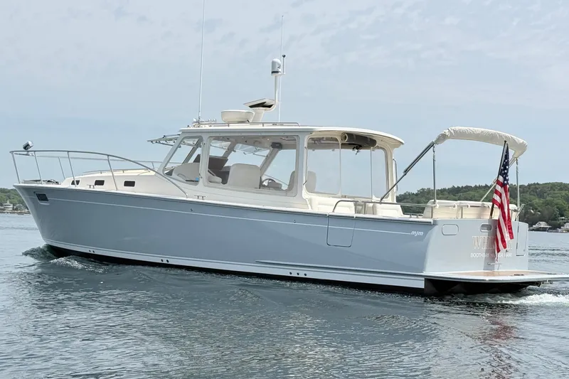 Slide: The Image of 2016 MJM 40z Downeast boat cruising on calm water with American flag. - 4