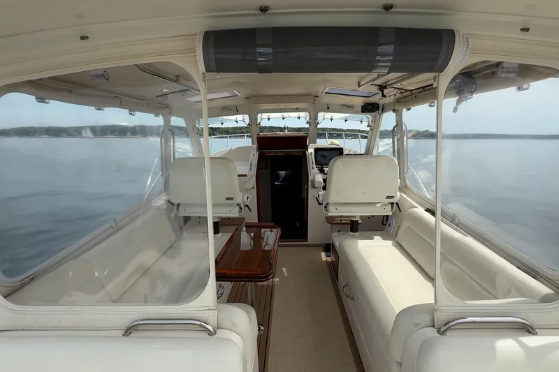 Slide: The Image of Interior view of a 2016 MJM 40z Downeast yacht, featuring elegant seating and panoramic windows. - 9