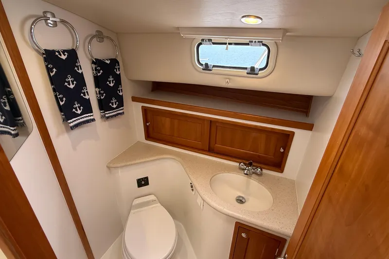 Slide: The Image of 2016 MJM 40z Downeast yacht bathroom with nautical-themed towels and wooden cabinetry. - 51