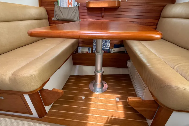 Slide: The Image of Interior of 2016 MJM 40z Downeast boat with wooden table and beige seating. - 23