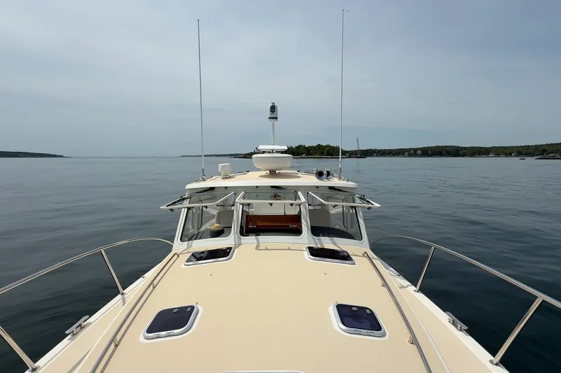 Slide: The Image of 2016 MJM 40z Downeast yacht on calm waters, showcasing sleek design and open deck. - 7