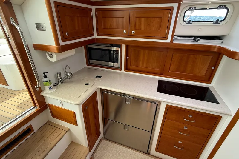 Slide: The Image of 2016 MJM 40z Downeast yacht kitchen with wood cabinets, sink, and modern appliances. - 27