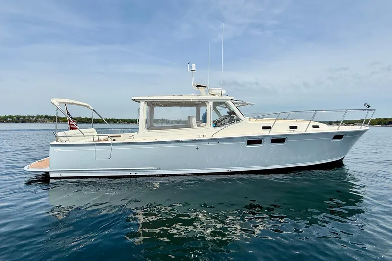 Slide: The Image of 2016 MJM 40z Downeast yacht on calm water, showcasing sleek design and luxury features. - 2