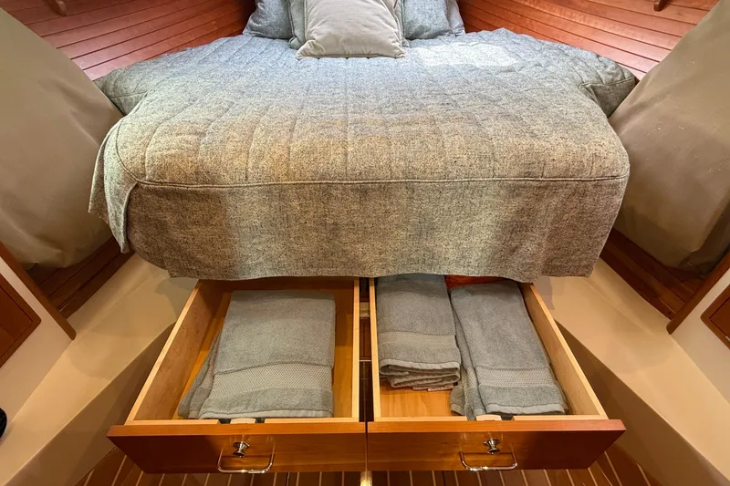 Slide: The Image of 2016 MJM 40z Downeast cabin with bed, storage drawers, and neatly folded linens. - 43