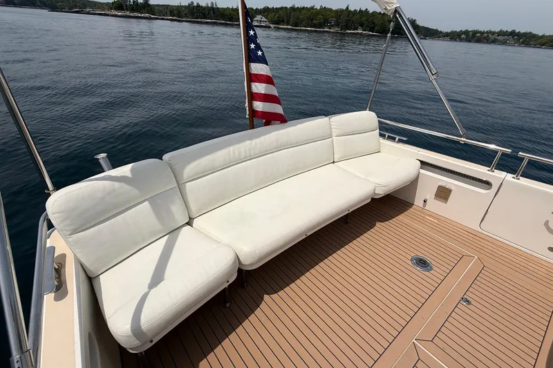 Slide: The Image of 2016 MJM 40z Downeast boat with white seating and American flag on deck. - 8