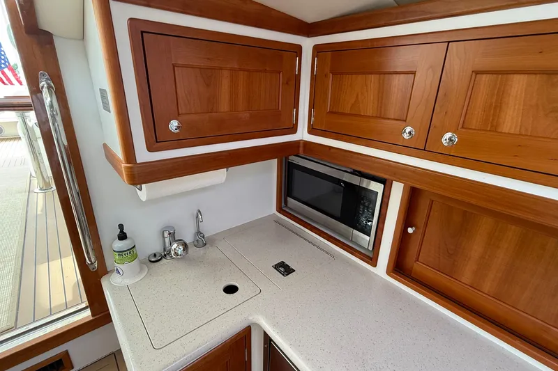 Slide: The Image of 2016 MJM 40z Downeast yacht galley with wooden cabinets, countertop, and built-in microwave. - 35