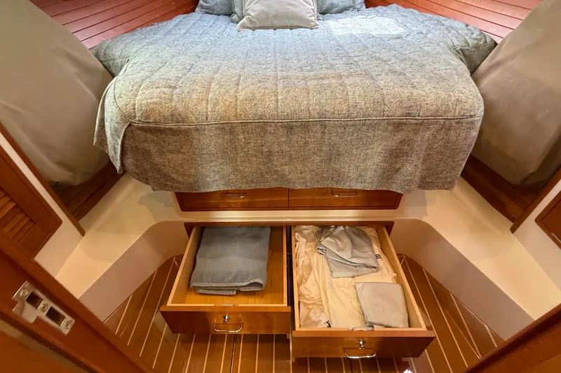 Slide: The Image of 2016 MJM 40z Downeast yacht cabin with bed and open storage drawers. - 42