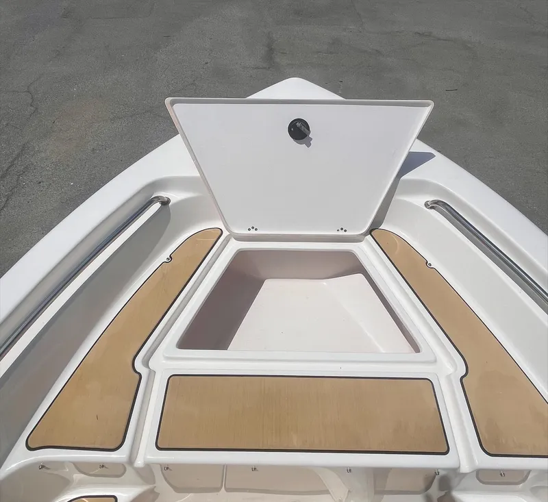 Slide: The Image of 2020 Key West 189 FS boat bow storage compartment with open hatch and tan deck padding. - 10