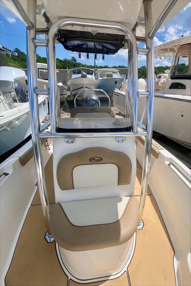 Slide: The Image of 2020 Key West 189 FS boat interior with seating and console, docked among other boats. - 8