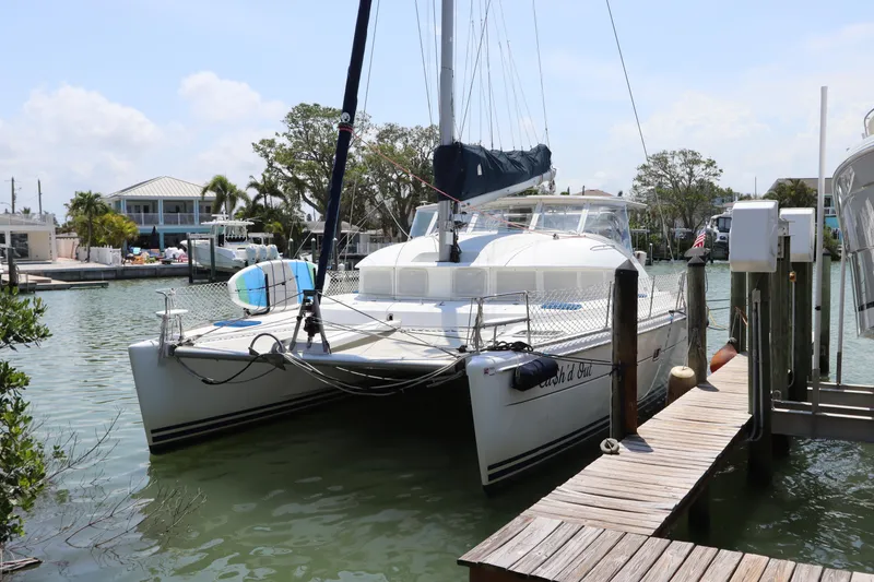 Slide: The Image of Lagoon 380 catamaran from 2001 docked at a marina with clear skies. - 0