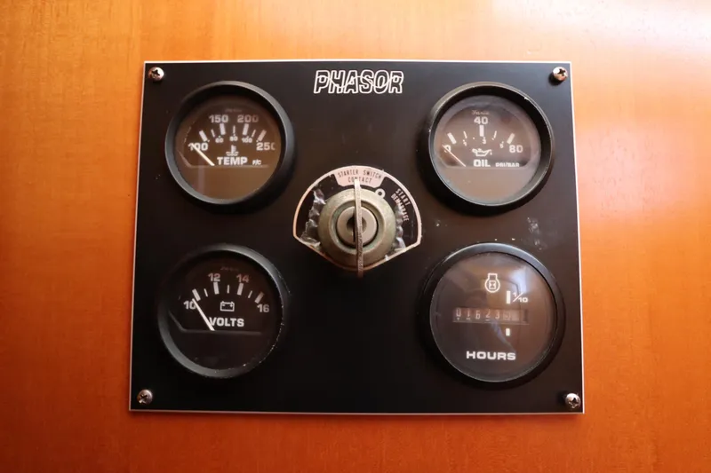 Slide: The Image of Control panel with gauges for temperature, oil pressure, volts, and hours on a 2001 Lagoon 380. - 12