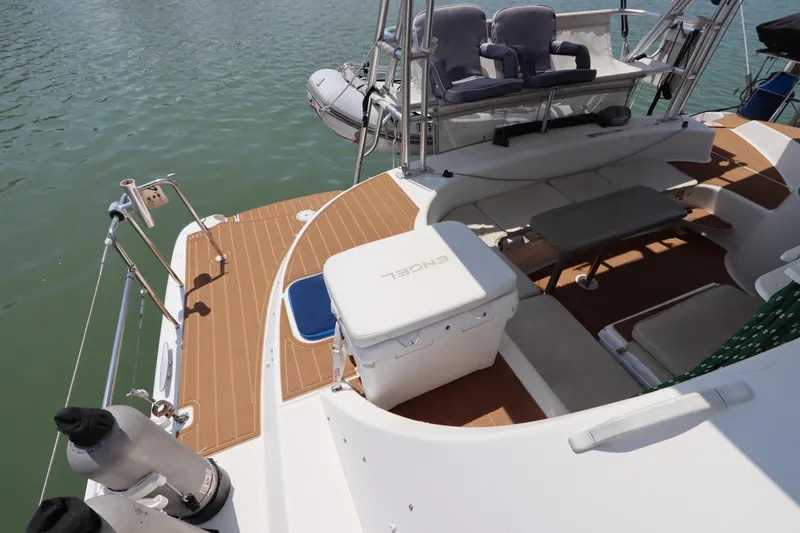 Slide: The Image of Lagoon 380 catamaran deck, 2001 model, featuring seating and storage, docked on calm water. - 18