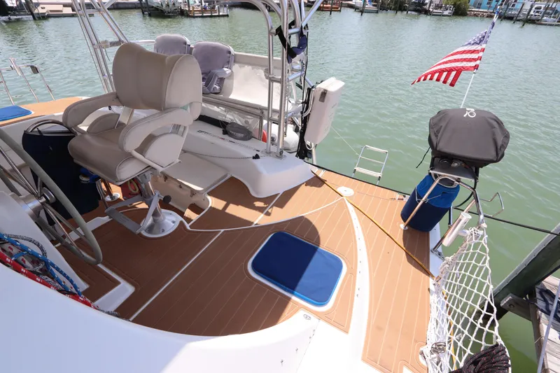 Slide: The Image of Lagoon 380 catamaran deck with seating, American flag, and water view, 2001 model. - 20