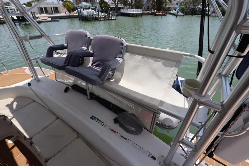 Slide: The Image of Lagoon 380 catamaran cockpit with cushioned seating, overlooking a serene marina, 2001 model. - 25