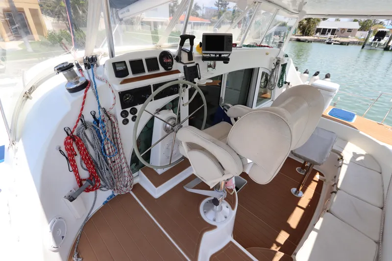 Slide: The Image of Cockpit of 2001 Lagoon 380 catamaran with steering wheel, ropes, and navigation equipment. - 27