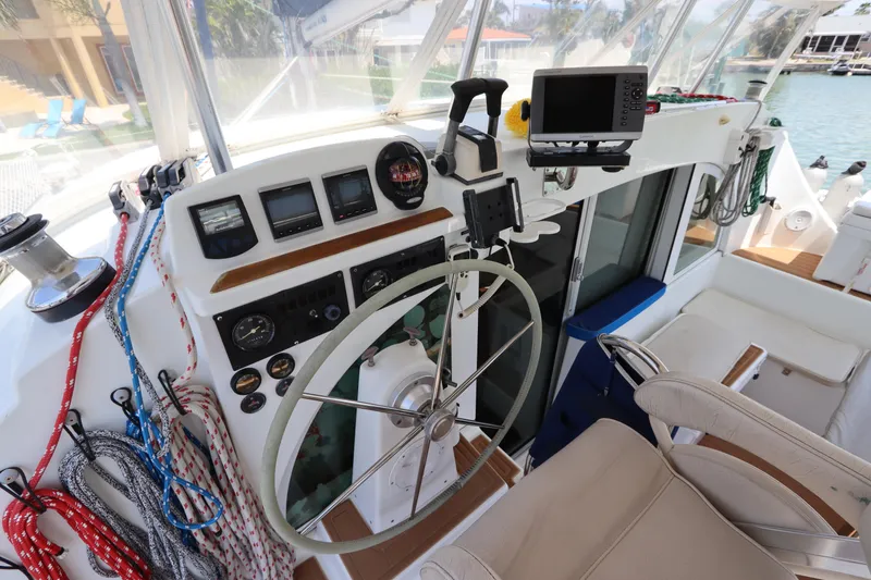 Slide: The Image of Cockpit of 2001 Lagoon 380 catamaran with steering wheel, navigation instruments, and ropes. - 28