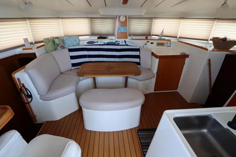 Slide: The Image of Interior of 2001 Lagoon 380 catamaran with cozy seating and wooden table. - 37