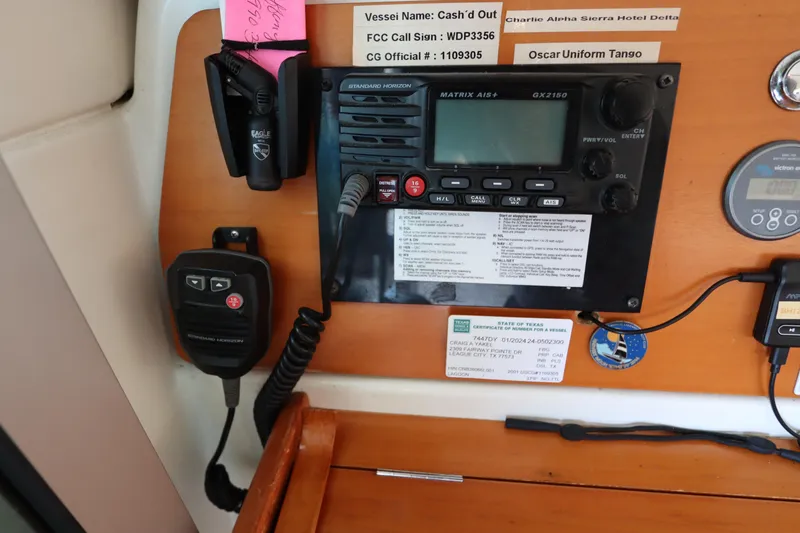 Slide: The Image of Control panel of a 2001 Lagoon 380 catamaran with communication equipment and vessel details. - 43