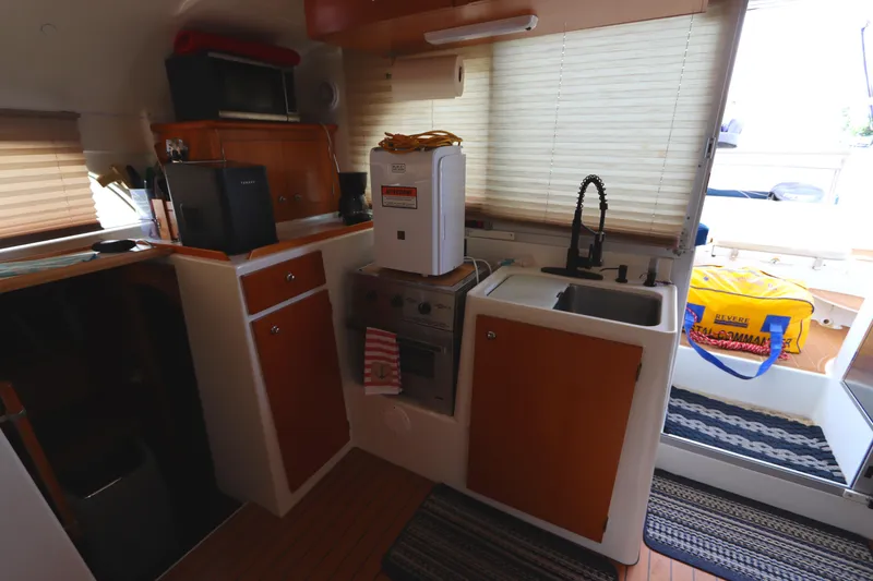 Slide: The Image of Interior of 2001 Lagoon 380 catamaran kitchen with appliances and wooden cabinetry. - 48