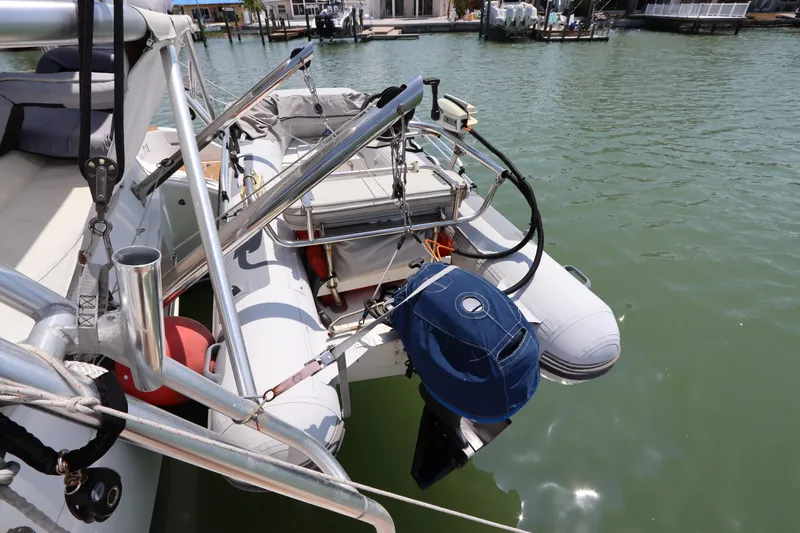 Slide: The Image of Inflatable dinghy attached to Lagoon 380 catamaran, 2001 model, docked in marina. - 5