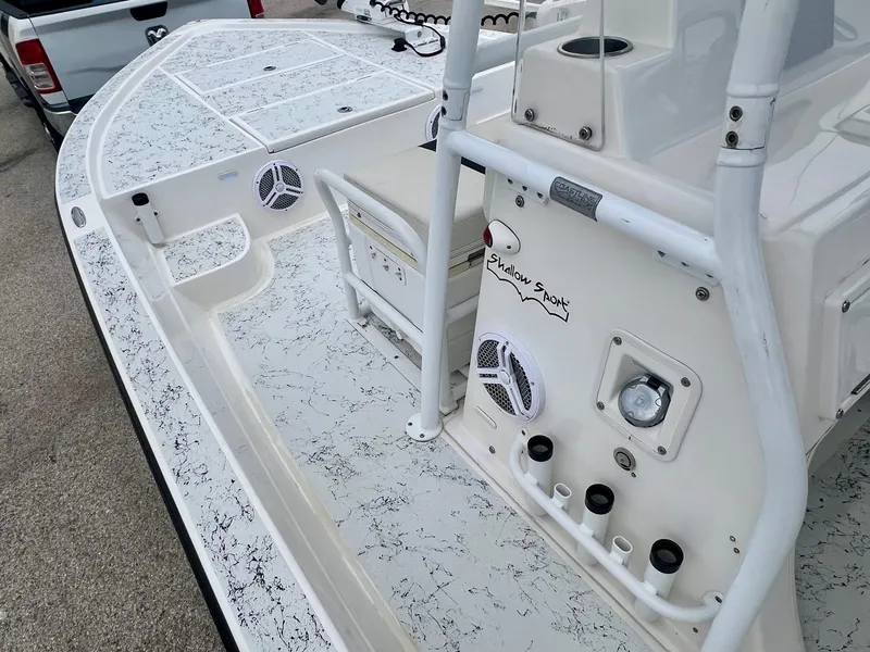 Slide: The Image of 2015 Shallow Sport 24 Modified V boat interior with white and speckled design, featuring speakers and storage. - 12