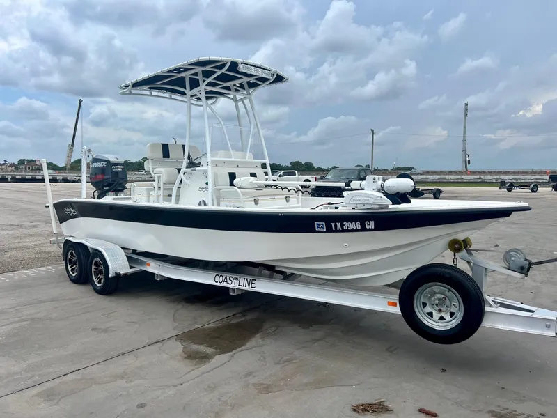 Slide: The Image of 2015 Shallow Sport 24 Modified V boat on trailer, parked outdoors under cloudy sky. - 5