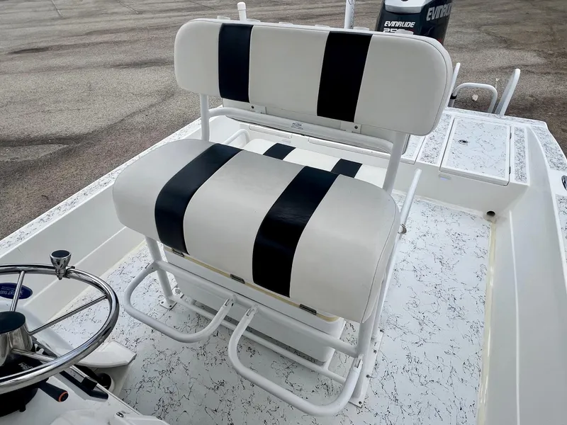 Slide: The Image of 2015 Shallow Sport 24 Modified V boat with striped seating and steering wheel. - 9