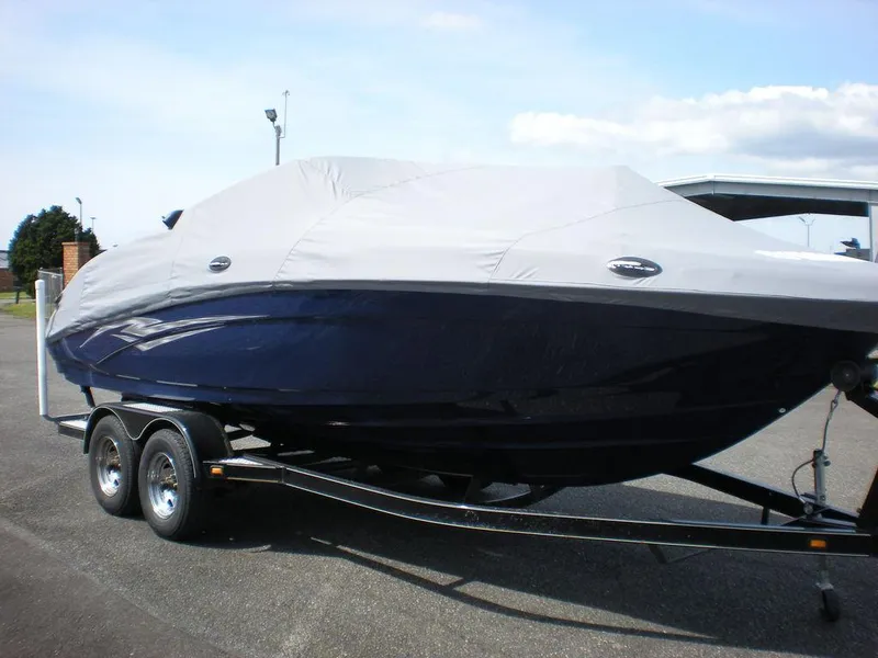 Slide: The Image of 2011 Yamaha AR210 boat covered on trailer, parked outdoors. - 13