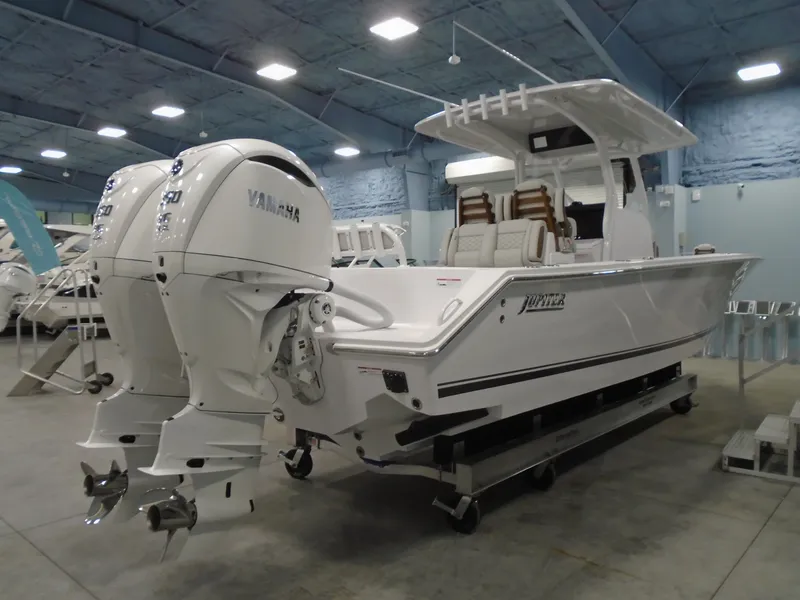 Slide: The Image of 2025 Jupiter 32 boat with twin Yamaha engines in a showroom. - 12