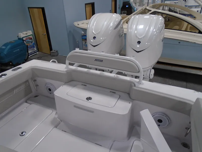 Slide: The Image of 2025 Jupiter 32 boat interior with dual outboard engines in showroom setting. - 14