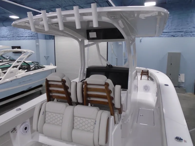 Slide: The Image of 2025 Jupiter 32 boat interior with cushioned seating and rod holders in a showroom. - 16
